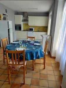 a kitchen with a table with a blue table cloth at La maison de rolland in Saint-Martin-lʼArs