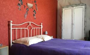 a bedroom with a bed with a purple blanket at La maison de rolland in Saint-Martin-lʼArs