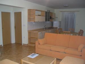 a living room with a couch and a kitchen at Apartments Luna in Tisno