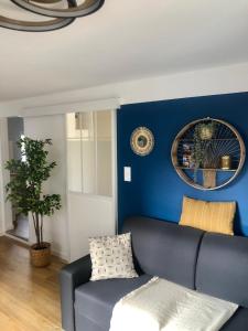ein Wohnzimmer mit einer blauen Wand und einer Couch in der Unterkunft T2 - Tram direct Strasbourg Centre Ville en 11 min - PARKING GRATUIT in Schiltigheim