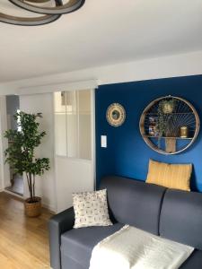 a living room with a blue wall and a couch at T2 - Tram direct Strasbourg Centre Ville en 11 min - PARKING GRATUIT in Schiltigheim +20 photos