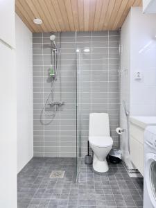 uma casa de banho com um WC e uma cabina de duche em vidro. em Stunning Central Apartment Helsinki em Helsínquia