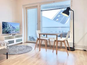 sala de estar con mesa, sillas y ventana en Stunning Central Apartment Helsinki en Helsinki