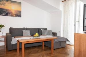a living room with a couch and a coffee table at Apartment Sun in Baška Voda