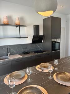 a kitchen with a table with plates and wine glasses at Cora May Central Villa with private pool 200m to the beach in Faliraki