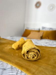 eine gelbe Decke auf einem Bett in der Unterkunft Ô Confluent in Montereau-faut-Yonne