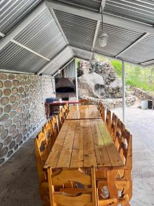 einen langen Holztisch mit Stühlen und einem Herd in der Unterkunft Hotel Halidzor in Halidzor