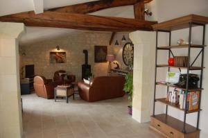 sala de estar con muebles de cuero marrón y pared de ladrillo en Domaine du haut vernay en Bournand