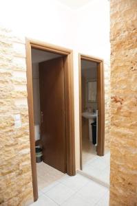 two open doors to a bathroom with a sink at Meropi Apartment in Preveza