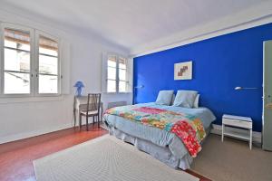 a blue bedroom with a bed and a chair at Les Félibres in Avignon