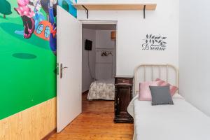 a small bedroom with a bed and a green wall at Los Balcones del Camino in Sahagún