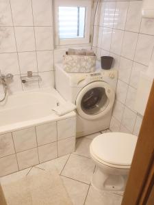 a bathroom with a toilet and a sink and a washing machine at Apartment Sun in Baška Voda +10 photos