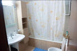 y baño con cortina de ducha y lavamanos. en Meropi Apartment, en Preveza