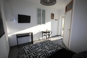 um quarto com uma cama, uma mesa e uma televisão em Gite montgolfiere em Châtellerault