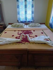 two twin beds in a bedroom with two bedsskirts at Balurghat Hotel KOKORO Farmhouse in Bālurghāt