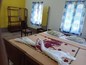 sypialnia z 2 łóżkami i ręcznikami w obiekcie Balurghat Hotel KOKORO Farmhouse w mieście Bālurghāt