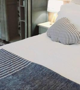 a white bed with a black and white comforter at The Old Barn Annexe, cosy stay, close drive to city, beach, South Downs & Goodwood in Chichester +17 photos