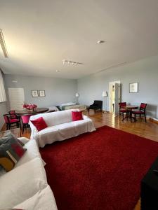 uma sala de estar com dois sofás brancos e um tapete vermelho em Burra Velha - Private House em Celorico de Basto
