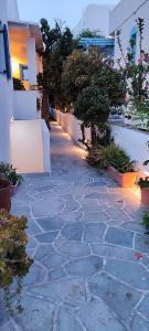 a stone walkway in a yard with trees and buildings at Maria Studios in Parikia