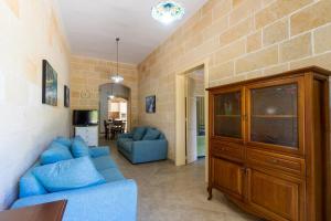 ein Wohnzimmer mit blauen Sofas und einer Ziegelwand in der Unterkunft Casa Maredoro by BarbarHouse in Nardò