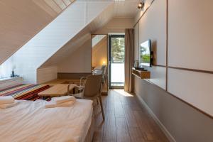 a hotel room with a bed and a table and chairs at Vellamo Dębki in Dębki