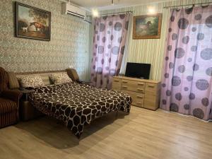 um quarto com uma cama, uma televisão e cortinas em Moskovs'kyi Avenue 80/82 em Kharkov