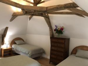 a bedroom with two twin beds and a wooden ceiling at Le gite de saint-maixent le petit in Haims