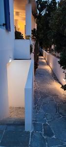 a white bench sitting on the side of a sidewalk at Maria Studios in Parikia