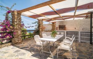 um pátio com uma mesa branca e cadeiras brancas em Nice Home In Adra With Private Swimming Pool, Can Be Inside Or Outside em Adra