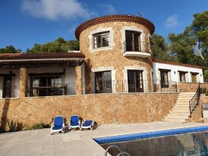una casa con 2 sillas y una piscina en Villa Torre Cal Sada, en Vall-Llobrega
