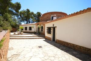 um pátio de uma casa com uma entrada de pedra em Villa Torre Cal Sada em Vall-Llobrega