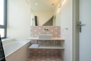 a bathroom with a tub and a sink and a bath tub at Vellamo Dębki in Dębki +42 photos