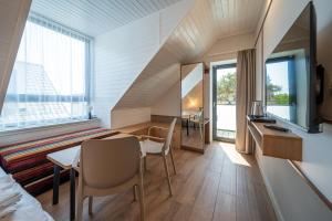 a room with a bed and a table and chairs at Vellamo Dębki in Dębki