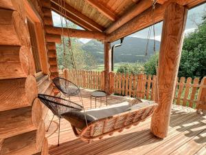 a porch with a hammock on a wooden deck at Lengalm Hütten I & II mit Sauna in Lengdorf