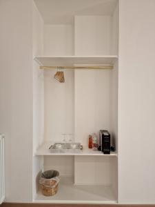 a white pantry with a sink and a microwave at Cuma Suites in Rome