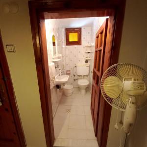 y baño con ventilador, aseo y lavamanos. en Family Holiday House, en Aydın