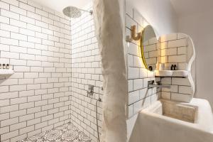 un bagno bianco con vasca e specchio di Gran Via Alsancak a Konak