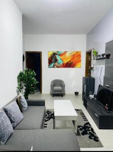 ein Wohnzimmer mit einem Sofa und einem TV in der Unterkunft Villa diam la paix in Guediawaye