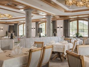 a restaurant with white tables and chairs and windows at Platzlhof - Mein Hotel im Zillertal in Ried im Zillertal