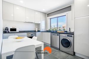 a white kitchen with a washer and dryer in it at #051 Cosy Apartment close to Beach in Albufeira