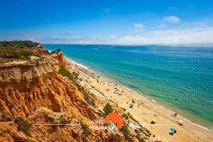 a view of a beach with people on a cliff at #051 Cosy Apartment close to Beach in Albufeira