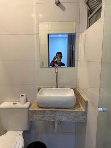 a person taking a picture of a bathroom sink at Hotel Estação Sé in São Paulo