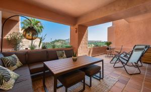 a porch with a couch and a table and chairs at Coto real Kiznos 2417 Lovely views in San Luis de Sabinillas