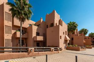 a building in the desert with palm trees at Coto real Kiznos 2417 Lovely views in San Luis de Sabinillas
