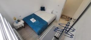 een klein bed met een blauwe hoes in een kamer bij Sunset Delux Apartment in Visoko
