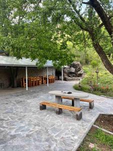 a picnic table and benches in front of a building at Hotel Halidzor in Halidzor