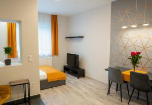 a bedroom with a bed and a table and a television at Vár Apartman in Eger