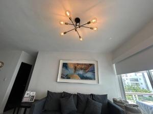 a living room with a couch and a chandelier at Acapulco Golden Sunset in Acapulco