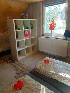 a bedroom with a bed and a window and a shelf at Chata pod zubačkou in Tatranska Strba