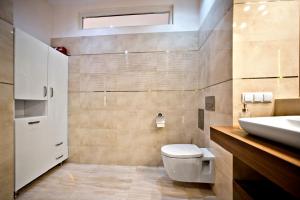 ワルシャワにあるNiepodleglosci Serviced Apartmentsのバスルーム(白いトイレ、シンク付)